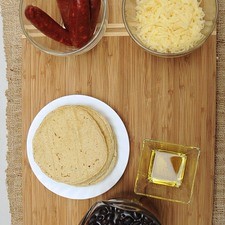 Ingredientes para receta 2 tazas de frijoles cocidos enteros 1 pieza de chile serrano 12 piezas de tortilla de maíz 300 gramos de chorizo 1 taza de queso manchego 1 cucharada de aceite de oliva