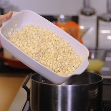 Colocar los granos de elote en una olla honda y cubrir con agua.