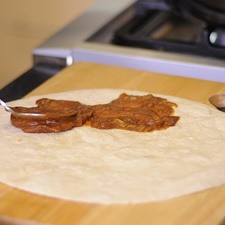 Untar cada tortilla con una capa de frijoles sólo en la mitad de la tortilla.