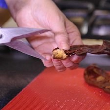 Cortar los chiles por un lado con una tijera. Remover el rabo, las semillas y las venas.