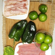 Ingredientes para receta 6 piezas de bistec de puerco 4 piezas de tocino ahumado 8 piezas de tomate verde (tomatillo) 1 diente de ajo 2 piezas de chile poblano 1 taza de elote desgranado Nuevo 3 piezas de penca de nopal 1 pizca de bicarbonato de sodio sal al gusto pimienta negra molida al gusto