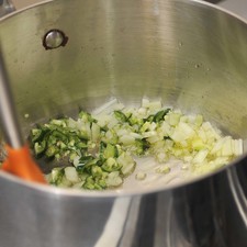Acitronar la cebolla picada y el chile serrano en una olla honda con aceite de oliva durante un par de minutos.