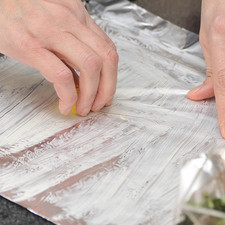 Untar bien con una cucharadita de mantequilla el centro de la mitad inferior de cada trozo de papel aluminio.