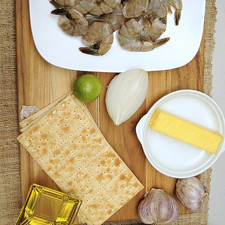 Ingredientes para receta 2 piezas de ajo 1/4 taza de aceite de oliva 90 gramos de mantequilla 1/4 pieza de cebolla blanca 1 kilogramo de camarón 40/50 1 pieza de limón sal al gusto pimienta negra molida al gusto galletas saladas al gusto