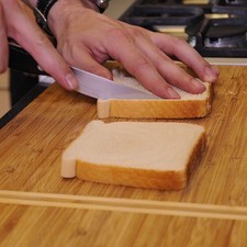 Hacer un corte en ambos lados de la rebanada del pan descartando las orillas.