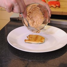 Colocar un poco del relleno encima del pan y cubrir con otro para formar el sándwich.