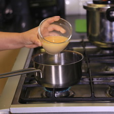 Agregar la mezcla de jugo en una olla con el azúcar. Calentar a fuego medio.