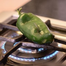 Asar el chile poblano sobre la lumbre directa de la hornilla hasta que se vea asado pero no quemado.
