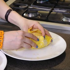 Envolver con los circulos de huevo la bola de arroz de la cara de pikachú, las orejas, hasta formar bien la cara.