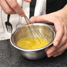 Preparar el aderezo mezclando el jugo de limón, el jugo de media naranja y las dos cucharadas de aceite de oliva en un tazón, batir con un batidor de globo.