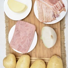 Ingredientes para receta 4 piezas de papa blanca 8 rebanadas de tocino ahumado 1/2 pieza de cebolla blanca 1 diente de ajo 300 gramos de jamón de pavo 250 gramos de queso manchego sal al gusto pimienta negra molida al gusto papel aluminio al gusto