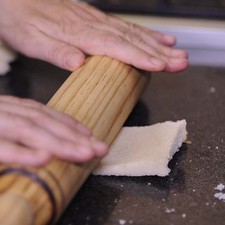 Extender las rebanadas de pan con un rodillo. NOTA: Las orillas se pueden guardar para tostar y moler y utilizarlas como pan molido.