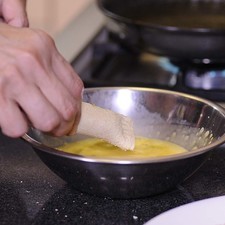 Pasar cada rollo por la mezcla de huevos batidos.
