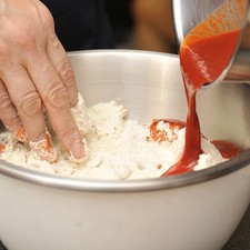 Colocar harina de maíz en un tazón y agregar media taza de salsa de chile colorado caliente.