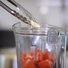 Colocar los jitomates partidos en cuartos, ajo en el vaso de la licuadora y moler bien.