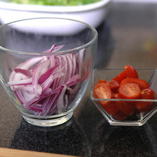 Cortar los tomates cherry por la mitad y la cebolla en rodajas.