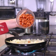 Agregar el chorizo y continuar cociendo hasta que el chorizo esté bien cocido pero no quemado.