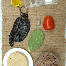 Ingredientes para receta 2 tazas de carne deshebrada de res 3 piezas de chile pasilla 1 diente de ajo 1 pieza de jitomate guaje sal al gusto pimienta negra molida al gusto 10 piezas de tortilla de maíz 1 cucharada de aceite de oliva 3 piezas de penca de nopal