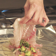 Poner la mezcla de verduras sobre éste y colocar otro filete encima. Tapar con otro trozo de papel aluminio y envolver muy bien para que no se escape el vapor.