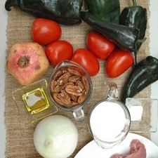 Ingredientes para receta 500 gramos de pulpa de cerdo 5 piezas de jitomate guaje 1 pieza de cebolla blanca 1/2 taza de uva pasa sal al gusto 2 cucharadas de aceite de oliva pimienta negra molida al gusto 2 piezas de duraznos en almíbar 6 piezas de chile poblano 1 diente de ajo Ingredientes para nogada 1 taza de crema de leche de vaca 190 gramos de queso crema 1 taza de nuez Ingredientes para decorar granada roja al gusto perejil fresco al gusto