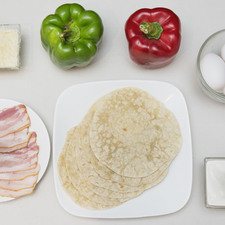 Ingredientes para receta 6 piezas de tortilla de harina 6 rebanadas de tocino 1/2 pieza de pimiento morrón rojo 1/2 pieza de pimiento morrón verde 4 piezas de huevo 1/4 taza de queso parmesano rallado 1/4 taza de crema de leche de vaca sal al gusto pimienta negra molida al gusto