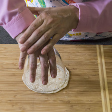 Colocar sobre la tabla de picar la tortilla de harina y con un cortador o un tazón de vidrio hacer un círculo.