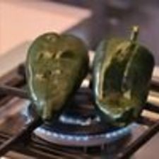 Tostar los chiles poblanos sobre la lumbre directa de la hornilla dando vuelta con una pinza. Hasta que se vean negros por todas partes.