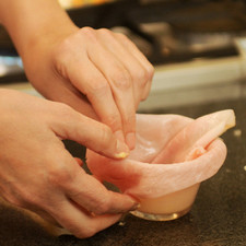 Untar los moldes de bollitos con mantequilla y colocar una rebanada de jamón dentro de cada uno como si quisiera forrarlo.