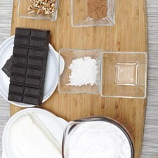 Ingredientes para para el chocolate 226 gramos de queso crema 2 1/2 tazas de azúcar glass (pulverizada) 140 gramos de chocolate amargo 1 cucharita de esencia de vainilla Ingredientes para para decorar nueces picadas al gusto cocoa en polvo al gusto coco rallado al gusto