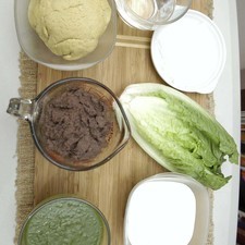 Ingredientes para receta 500 gramos de masa de maíz 2 tazas de frijol refrito negro Nuevo 1 pieza de lechuga orejona 1 taza de crema 1/4 taza de salsa verde queso fresco al gusto agua tibia al gusto sal al gusto