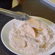Pelar la manzanas y quitar el centro, se cortar en gajos y revolcar en harina con 1/2 Taza de azúcar y canela. colocar los gajos sobre la tartaleta.