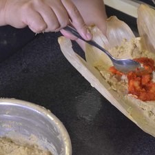 Para armar los tamales, colocar dos cucharadas de masa dentro de la hoja, poner un poco del relleno de camarón.