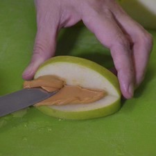 Unta mantequilla de cacahuate adentro de la manzana para que parezca la piel de la boca.