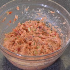 Añadir mostaza, sal y pimienta negra molida, revolver bien con la mano para integrar todos los ingredientes.