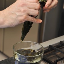 Pelarlos con la mano, sumergiéndola en agua cada vez que se la pasa por el chile para descartar la piel quemada.