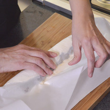 Enrollar el queso ayudándose con el papel. hasta que los ostiones queden perfectamente envueltos de queso.