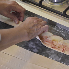 Colocar 7 rebanadas de manzana una sobre otra a la mitad de la anchura de la masa.