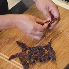 Para preparar el adobo, desvenar los chiles morita.