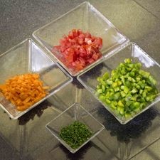 Picar finamente jitomate, zanahoria, cebollín y pimiento morrón verde descartando la parte blanca y reservar.