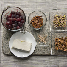 Ingredientes para receta 190 gramos de queso crema 3 tazas de uva morada 1/2 taza de nuez 1/2 taza de almendras palillos al gusto papel encerado al gusto 1/2 taza de pistache