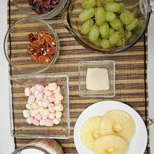 Ingredientes para receta 1 1/2 tazas de yogurt griego natural 4 rebanadas de piña en almíbar 1/2 taza de nuez 1/2 taza de arándanos deshidratados 1 taza de malvaviscos 2 cucharadas de azúcar blanca