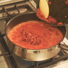 Picar la cebolla, calentar la manteca en otro sartén y acitronar la cebolla hasta que se torne un poco transparente, agregar la salsa y dejar cocinar cinco minutos. Añadir la longaniza.