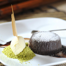 Para servir añadir una cucharada de salsa de chocolate y esparcir sobre el plato con la ayuda de una espátula. Añadir una cucharada de polvo de macarrón cerca de la salsa. Desmoldar el volcán de chocolate, espolvorear un poco de azúcar glass colocar una bolita de helado sobre el polvo de macarrón y decorar con una teja. Servir inmediatamente. S 15259 1475612004