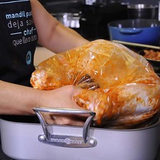 Para hornear el pavo, acomodar el pavo en la bolsa para hornearlo y colocarlo sobre la charola honda.