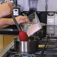 Verter la gelatina de frambuesa en dos tazas de agua caliente, mezclar hasta integrar.