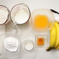 Ingredientes para receta 1 pieza de huevo 2 tazas de harina de trigo 3 cucharadas de azúcar blanca ralladura de cáscara de mandarina al gusto Nuevo 1/2 taza de jugo de mandarina leche de vaca al gusto 3 piezas de plátano aceite vegetal comestible al gusto azúcar glass (pulverizada) al gusto servilletas de papel al gusto Help 1 cucharita de polvo para hornear (levadura química)