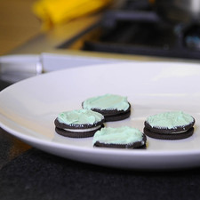 Cuando se derrita bajar la temperatura, agregar el colorante verde hasta obtener el color deseado, untar un poco a cada galleta, servirá para que la fresas se peguen.