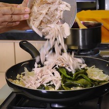 Agregar las rajas de chile y el pavo deshebrado y mezclar un poco para que tomen sabor.