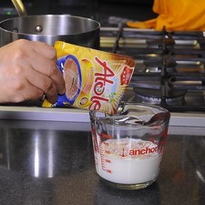 Disuelve el Atole Tres Estrellas® sabor chocolate en una taza de leche fría.