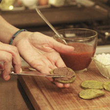 Untar cada círculo de nopal asado con un poco de frijoles refritos.